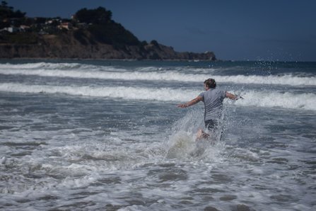 Man running against the waves