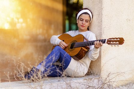 Pensive girl playing guitar