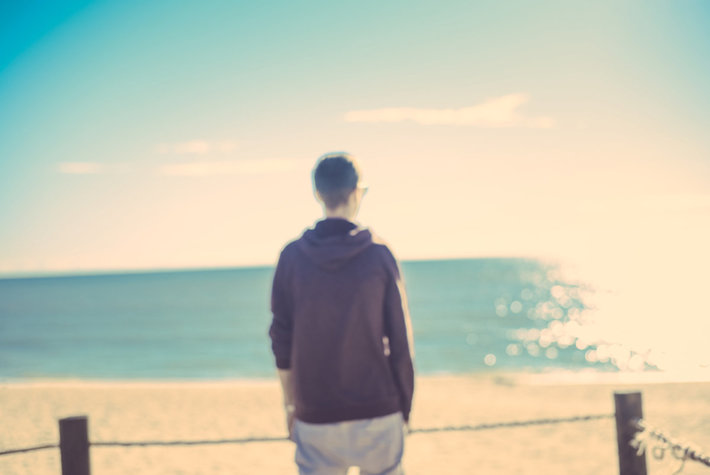 Young guy standing at the beach
